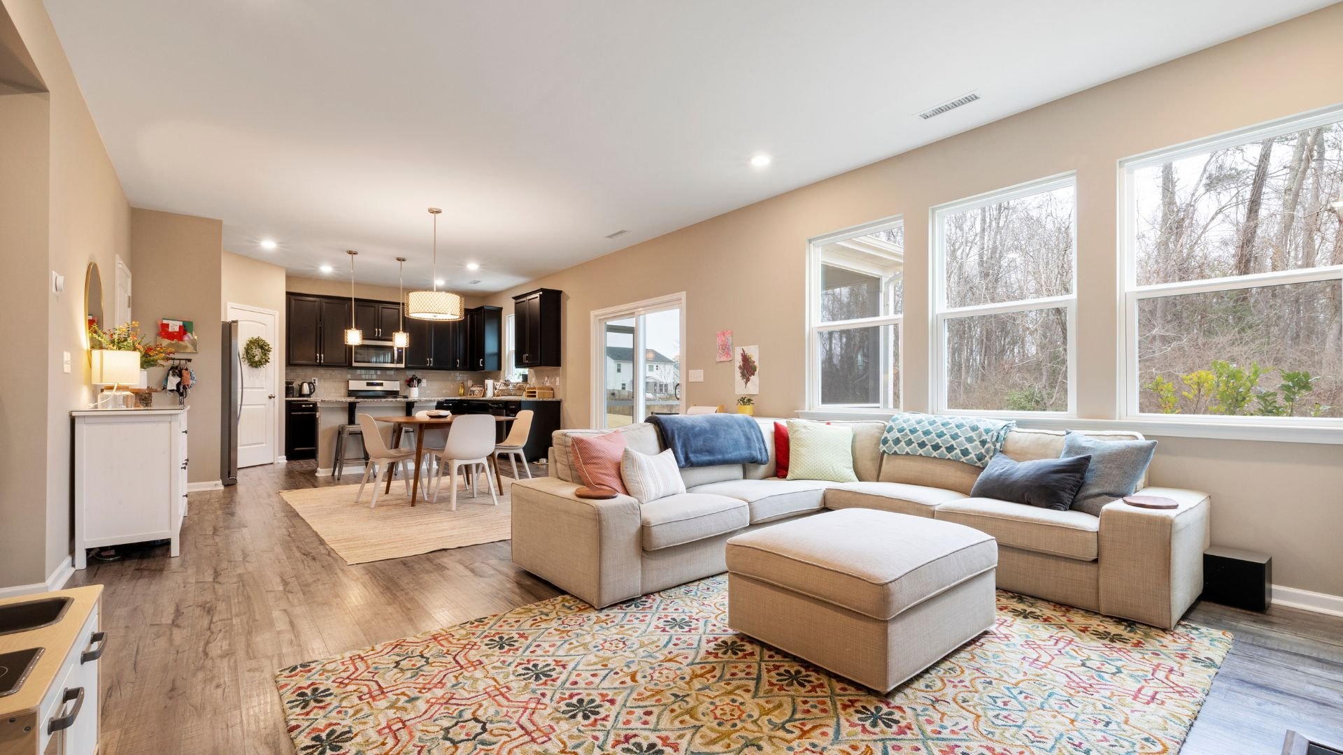 Modern open-concept living space with kitchen, dining area, and cozy seating